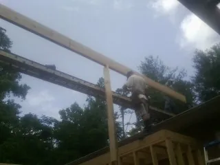 Carpenter setting a ridge beam over a new addition frame — Ice Dam Removal by Roofing Brothers in Lansdale