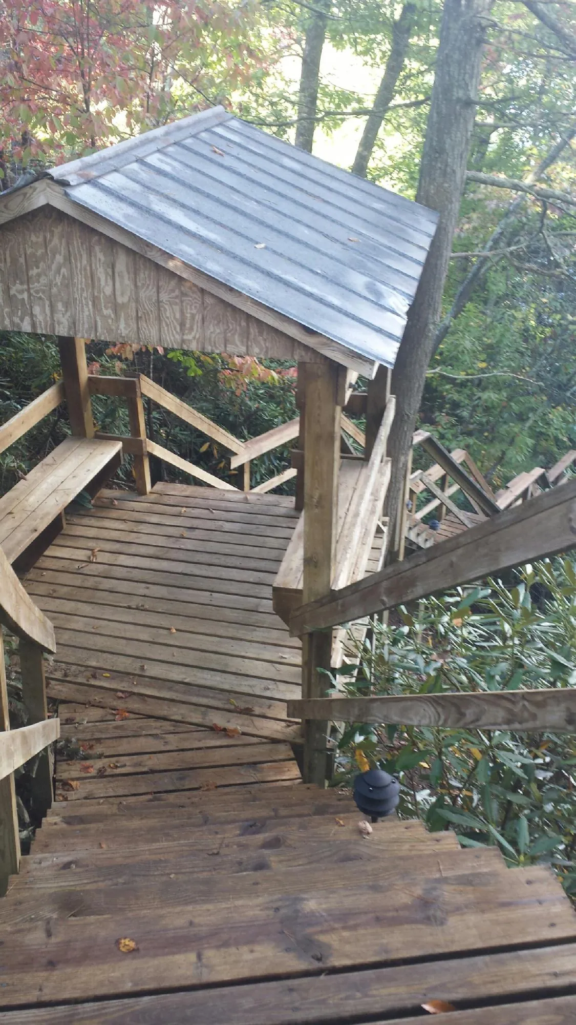 Metal roofed shelter over wooden steps on a wooded walkway — Skylight Repair & Installation work by our crew in Lansdale