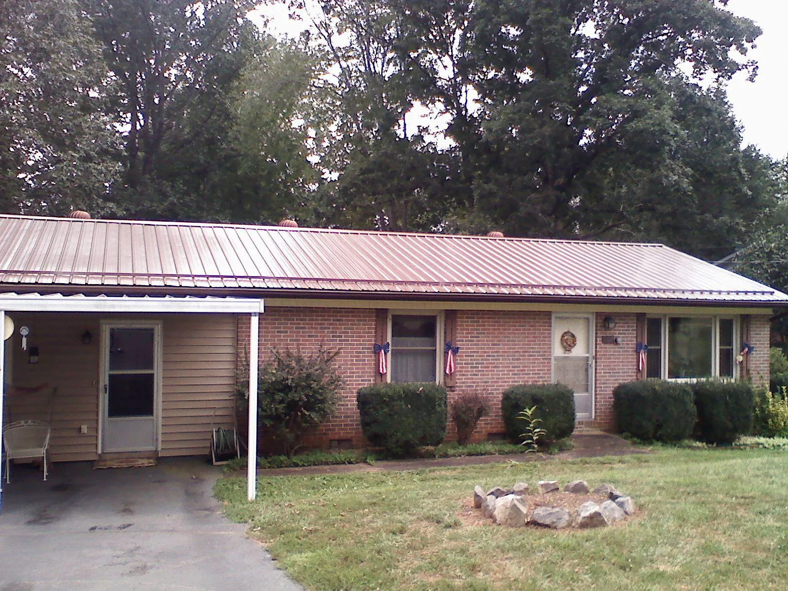 Bronze metal roof and carport on a brick ranch home — Roof Repair work by our crew in Lansdale